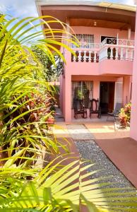 a pink house with plants in front of it at Departamento Ángeles del Arenal #2 in Fortuna