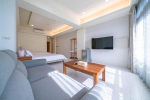 a living room with a couch and a tv at Manman B&B in Tainan +28 photos
