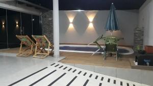 una stanza con sedie e ombrellone e una piscina di Casa com piscina bem localizada a Anápolis