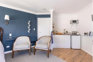 a kitchen with two chairs and a table in a room at Potager B&B- Waiohine- Greytown in Greytown +13 photos