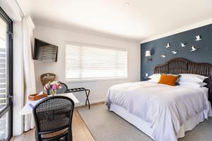 a bedroom with a large bed and a window at Potager B&B- Waiohine- Greytown in Greytown