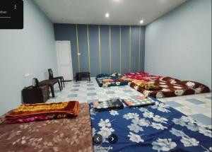 科塔吉里HaMy Resort, Kotagiri的一间卧室，有两张床和一面蓝色的墙