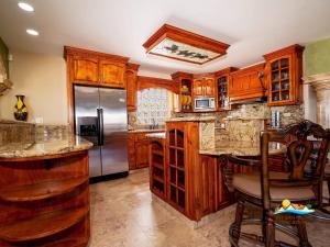a kitchen with wooden cabinets and a stainless steel refrigerator at Luxury 3-Story Beachside Villa in San Felipe with Private Pool – Casa Mostaza in San Felipe +21 photos
