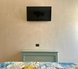 a bedroom with a bed with a tv on the wall at KarEmm in Polignano a Mare