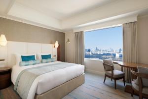 a hotel room with a bed and a desk and a window at Grand Nikko Tokyo Daiba in Tokyo
