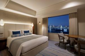 a hotel room with a bed and a table and a window at Grand Nikko Tokyo Daiba in Tokyo