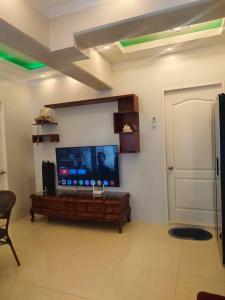 Uma televisão e/ou sistema de entretenimento em Cosy Nest Royal Oceancrest Mactan