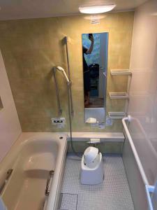 un bagno con vasca e una persona che scatta una foto di 2 Double bed and 1 Sofa bed Fullsize bathroom Shinjuku 20 minutes Quiet cozy room Walmart DonDonDonk Station 7 minutes Free parking at Tanashi Station a Nishitokyo Altre 67 foto