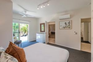 Un dormitorio con una cama blanca y una sala de estar. en Cooinda Gardens 6 on Hamilton Island by HamoRent, en Hamilton Island 19 fotos más
