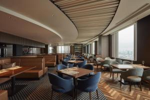 a restaurant with tables and chairs and a large window at Grand Nikko Tokyo Daiba in Tokyo