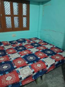 a quilt on a bed in a room at saket guest house in Ayodhya