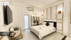 a bedroom with a white bed and a tv at A In Hotel Glamour in Ho Chi Minh City