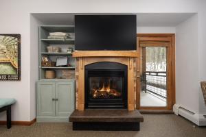a living room with a fireplace with a tv on top at Premium Unit 1305 - Zephyr Mountain Lodge condo in Winter Park