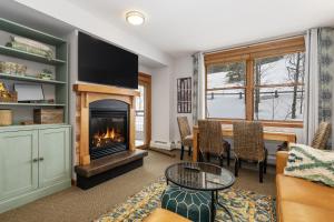 a living room with a fireplace and a table at Premium Unit 1305 - Zephyr Mountain Lodge condo in Winter Park