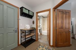 a hallway with a door leading to a bathroom at Premium Unit 1305 - Zephyr Mountain Lodge condo in Winter Park +7 photos