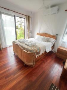 Ce lit se trouve dans un dortoir doté de parquet. dans l'établissement Punta colorada, casa con jacuzzi dos baños, à Punta Colorada