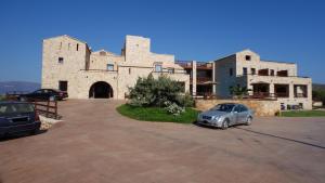 a car parked in a parking lot in front of a building at Simosmare Resort in Elafonisos
