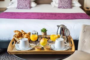 a tray of breakfast food on a table in a hotel room at hotel Louvre Sainte Anne in Paris +21 photos