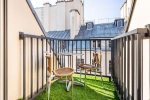 a balcony with two chairs and a table at hotel Louvre Sainte Anne in Paris