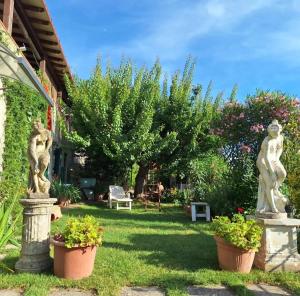 two statues in the yard of a house at VETULONIA ROMANTICA in Vetulonia