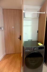 a washing machine in a room with a door at AH/Luxe penthouse con balcón,Wifi+Parking; Usaquén in Bogotá