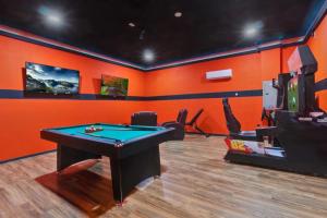an orange room with a pool table and a tv at 491-8-LD-Private Pool with Game and Movie in Orlando