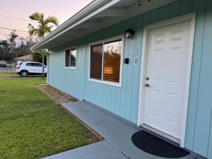 帕霍阿Aloha Hale的白色门的小蓝色房子