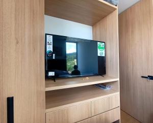 ボゴタにあるAH/ Panorámico Piso11, Balcón, Parking, Bgta Norteの木製のキャビネットに入った大型の薄型テレビ