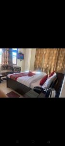 a bedroom with a large bed with red pillows at rudra cottage in Shimla