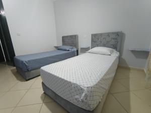 two twin beds in a room with at Appartement dans Résidence avec piscine Marina P13 in Saidia  +24 photos