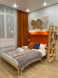 a bedroom with a bed with a wooden headboard at Contento Apartments in Almaty