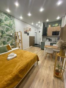 a bedroom with a large bed and a kitchen at Contento Apartments in Almaty