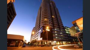 Un palazzo alto in una strada di città di notte di Pandanas Apt 2 (10th floor, Pool & City views) a Darwin