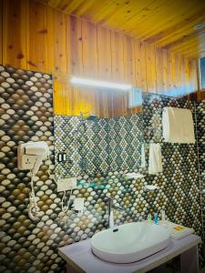 une salle de bain avec un lavabo et un mur en pierre dans l'établissement Easton Blue Hotel, à Ilām 20 autres photos