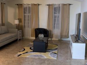 a living room with a chair and a television at Bridgeview Arcadia Three in Portmore