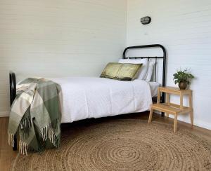a bedroom with a bed and a table and a clock at Sailors Snug in Kelso