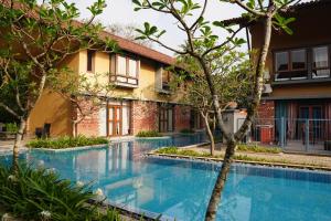a swimming pool in front of a house with trees at Casa Del Rio in Raichak