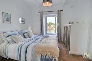 a bedroom with a large bed and a refrigerator at La maison du pont in Trédarzec