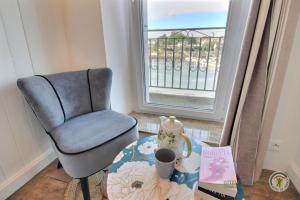 a chair and a table in a room with a window at La maison du pont in Trédarzec +31 photos