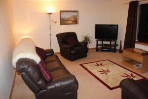 a living room with a leather couch and a television at Bitacora in Hallin