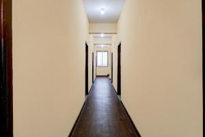 an empty hallway with a long wooden floor and white walls at Hotel O Bharat Institute of Engineering Hyderabad Formerly Blue Petals in Hyderabad