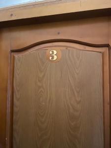 Una puerta marrón con el número tres. en Art Luxury studio, en Burgas