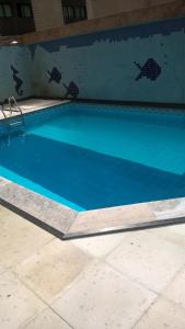 a large blue swimming pool in a building at Boa Viagem Flat BVF 777 in Recife