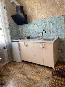 una cucina con mobili bianchi e un lavello di Hotel Kobuleti a Kobuleti