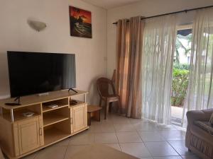 TV in/ali zabaviščno središče v nastanitvi Apartment Tamarinier Complexe