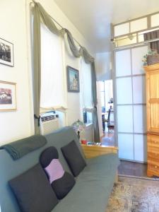 a living room with a couch with a person sitting on it at East Village Homestay in New York