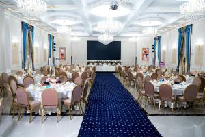 a banquet hall with tables and chairs and a screen at Гостиница Asan Ali in Kapchagay