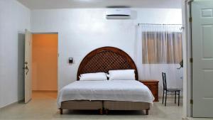 a bedroom with a bed with two pillows on it at Hotel Hacienda Margot in Valladolid