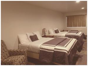 une chambre d'hôtel avec deux lits et une chaise dans l'établissement Harbour Inn, à Parker