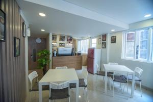 a room with two tables and chairs and a kitchen at Flagship 101 Apple Platinum in Jakarta